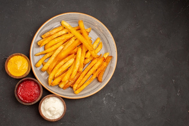 Top view delicious french fries with seasonings on dark desk dish potato meal fast-food burger