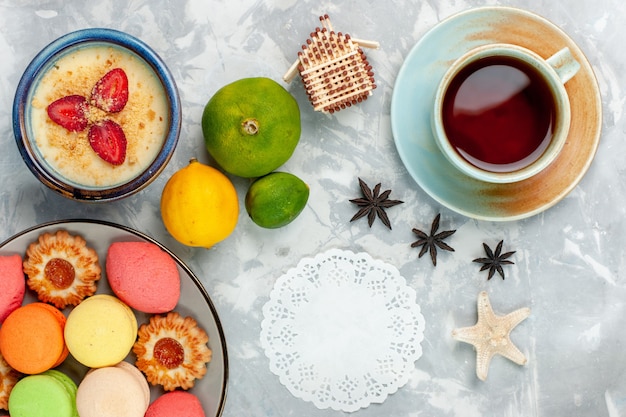 Top view delicious french macarons with cookies dessert and tea on light-white background bake cake biscuit sugar sweet photo