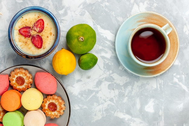 Top view delicious french macarons with cookies dessert and tea on light white background bake cake biscuit sugar sweet photo