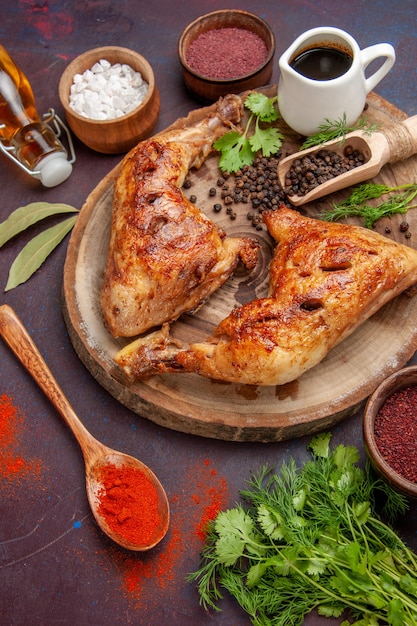 Top view delicious fried chicken with different seasonings on dark desk