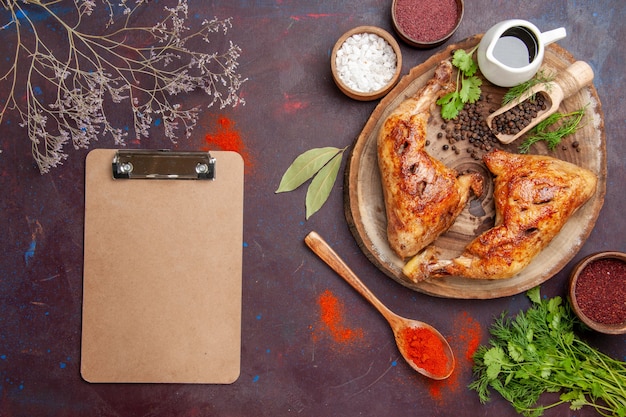 Free photo top view delicious fried chicken with different seasonings on a dark space