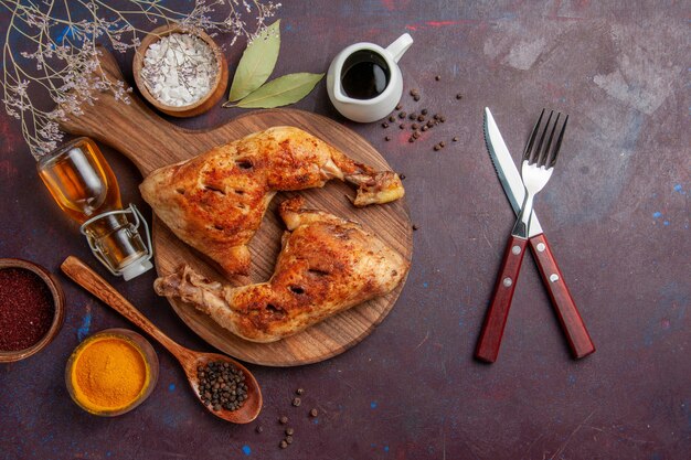 Top view delicious fried chicken with different seasonings on dark space