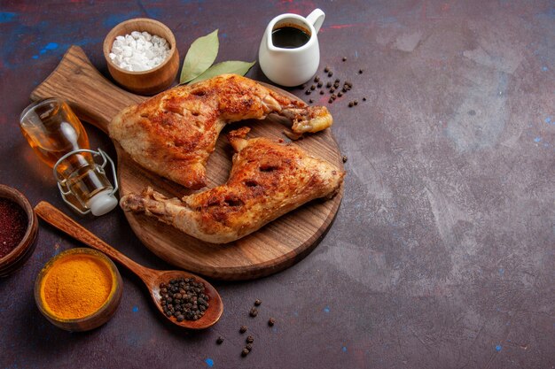 Top view delicious fried chicken with seasonings on a dark space