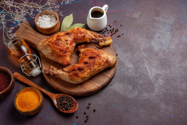 Top view delicious fried chicken with seasonings on the dark space