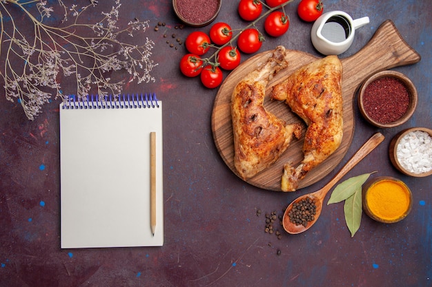 Top view delicious fried chicken with seasonings and vegetables on dark floor meat chicken meal food dish