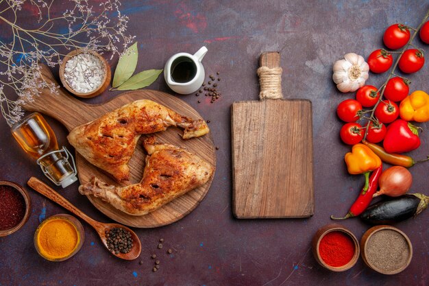 Top view delicious fried chicken with seasonings and vegetables on a dark space