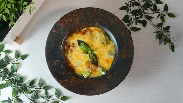 Free photo top view of delicious frittata on a black plate on a wooden surface