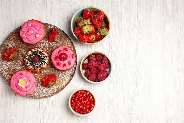 Free photo top view delicious fruit cakes creamy desserts with fruits and berries on a white background cream tea sweet cake cookie dessert