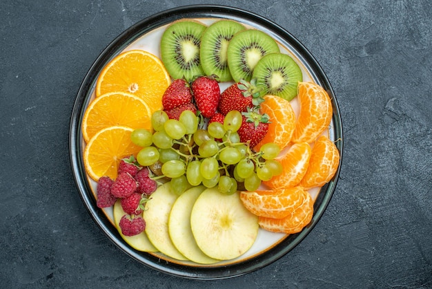 Top view delicious fruit composition fresh sliced and mellow fruits on dark background ripe fresh mellow vitamine health diet