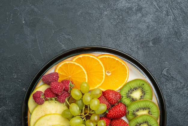 Top view delicious fruit composition fresh sliced and mellow fruits on dark floor ripe fresh mellow health diet