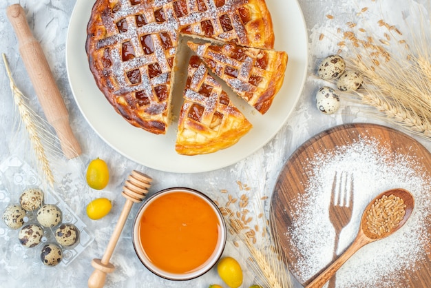 Top view delicious fruit pie with flour on white table cake sweet dough eggs sugar tea cutlery biscuit bake