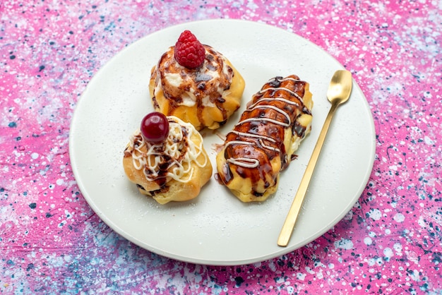 Free photo top view delicious fruity cakes with cream and chocolate inside white plate on the pink background cake biscuit sweet bake