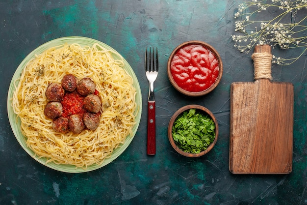 Free Photo top view delicious italian pasta with meatballs and tomato sauce on the dark blue background dough pasta food meal dish dinner