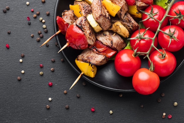 Top view of delicious kebab with tomatoes on plate