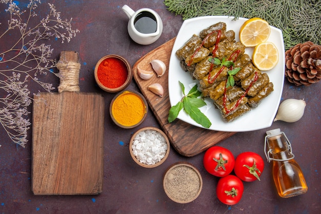 Free photo top view delicious leaf dolma with lemon slices and seasonings on dark background meal dish leaf meat dinner food