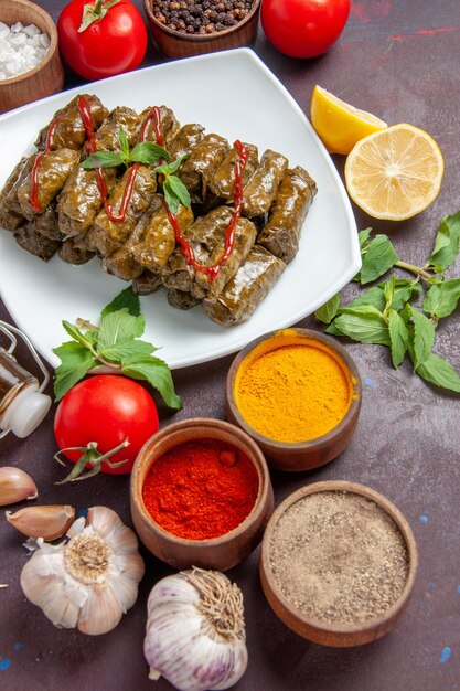 Top view delicious leaf dolma with seasonings and tomatoes on dark background dish leaves food meat dinner