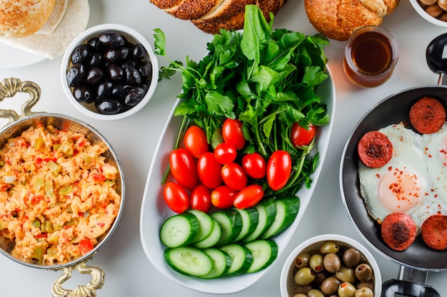 Free photo top view delicious meals in pan and pot with salad, pickles, turkish bagel, a cup of tea on white surface