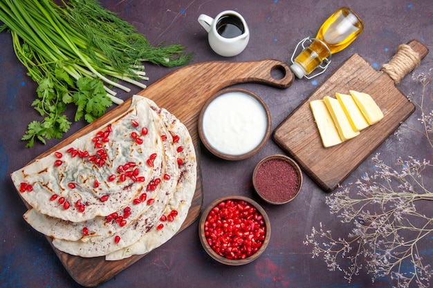 Free photo top view delicious meat qutabs pitas with fresh red pomegranates on dark surface dough meal food pita