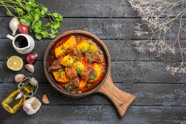 Free Photo top view delicious meat soup with potatoes and greens on dark desk