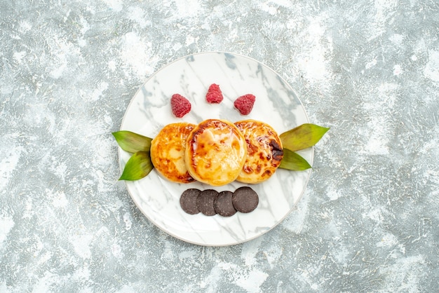 Free Photo top view delicious muffins with honey and choco biscuits on light background