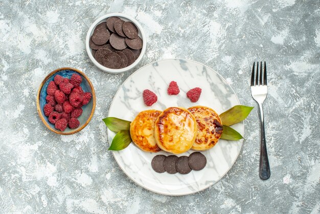 Free photo top view delicious muffins with honey and choco biscuits on light background