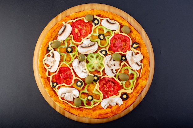 Top view delicious mushroom pizza with red tomatoes bell-peppers olives and mushrooms all sliced inside on the dark desk food meal pizza italian