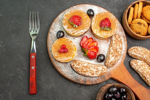 Top view delicious pancakes with fruits and sweet cakes on dark floor cake dessert sweet