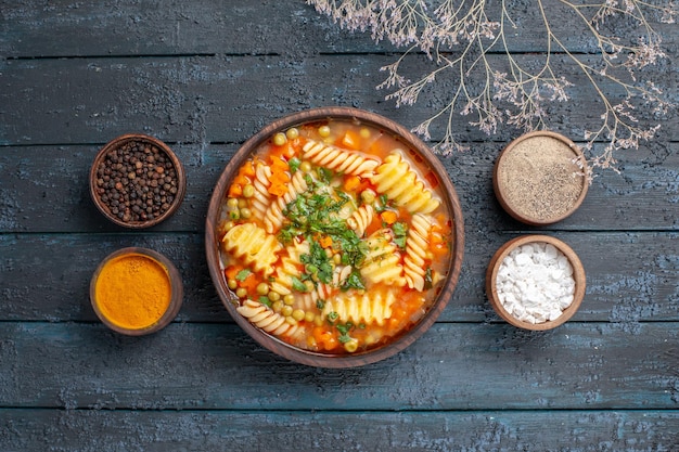 Top view delicious pasta soup from spiral pasta with seasonings on dark-blue desk sauce cuisine dish italian pasta soup