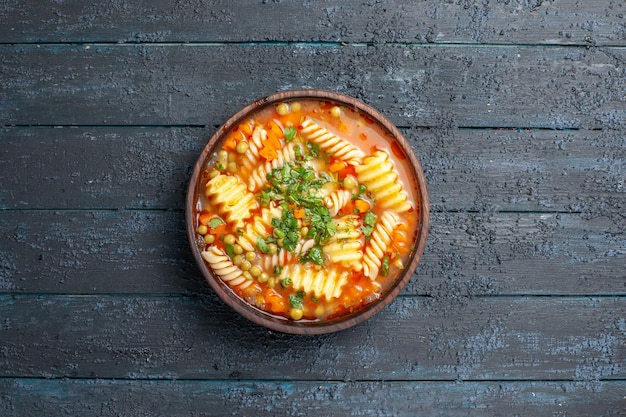 Free photo top view delicious pasta soup with greens and vegetables inside plate on a dark desk dish italian pasta soup meal dinner