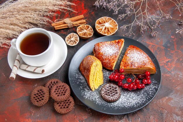 Top view delicious pie with cup of tea on dark table cake sweet pie tea