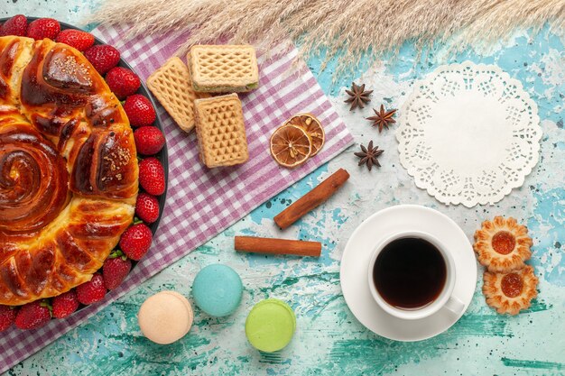 Top view delicious pie with strawberries and waffles on light blue surface