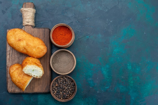 Free photo top view delicious pies with meat filling and seasonings on dark-blue background dough pie bread bun bake