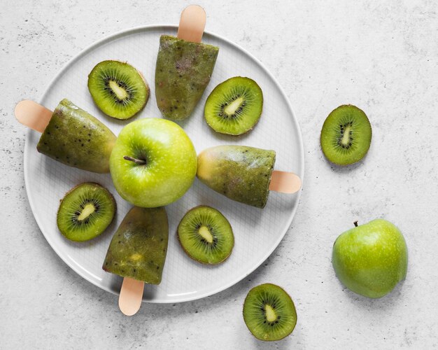 Top view of delicious popsicles with apples and kiwi