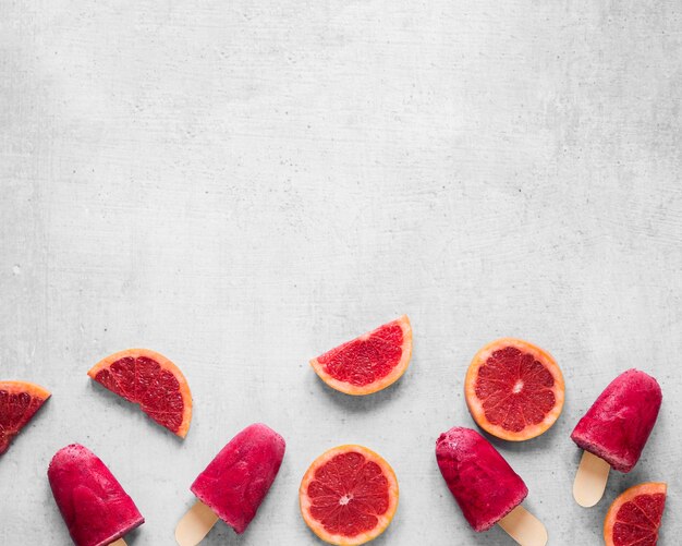 Top view of delicious popsicles with red grapefruit and copy space