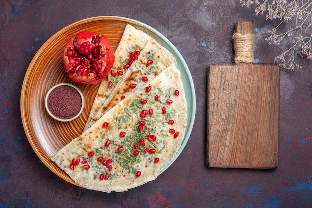 Free photo top view delicious qutabs cooked dough pieces with greens on dark surface dough meal dinner dish cooking