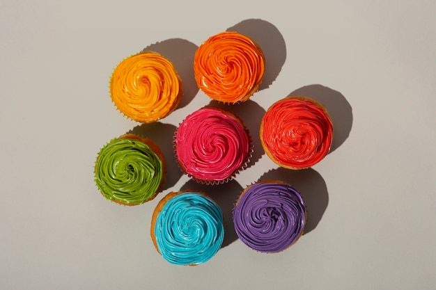 Free photo top view delicious rainbow cupcake glaze still life