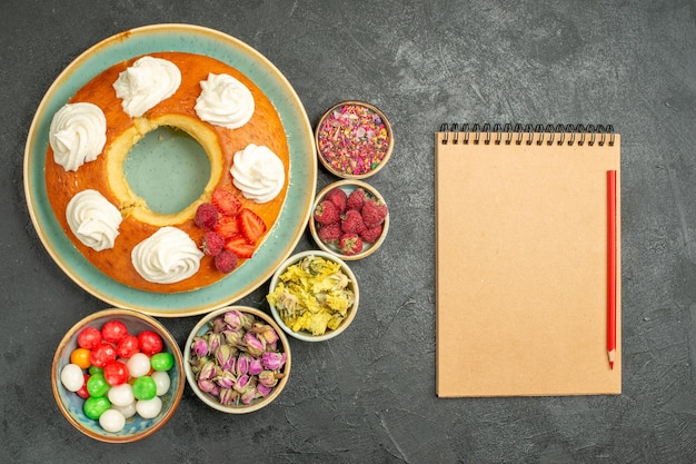 Top view delicious round pie with candies on the grey background sugar cookie biscuit cake pie sweet tea