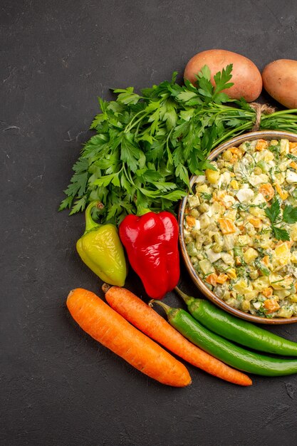 Top view of delicious salad with fresh vegetables on dark surface