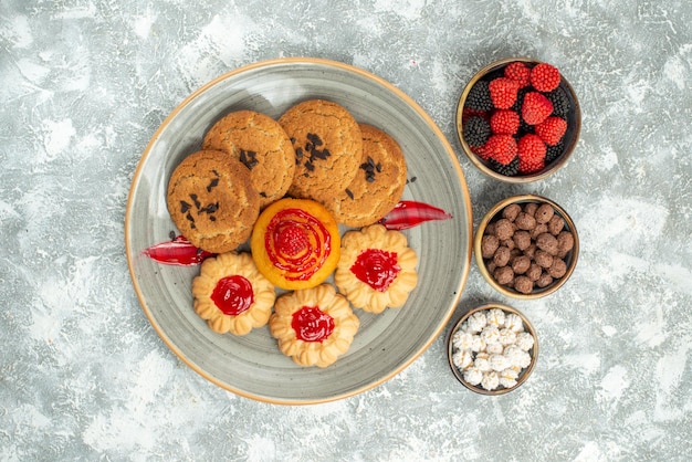 Top view delicious sand biscuits with cookies and candies on white background sugar biscuit cake cookies tea sweet