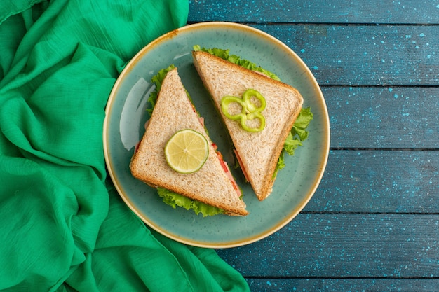 Free Photo top view of delicious sandwiches inside blue plate on the blue desk