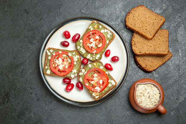 Top view delicious sandwiches with avocado pasta and tomatoes inside plate on grey surface burger sandwich bun snack bread