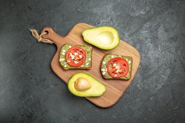 Top view delicious sandwiches with avocado and red tomatoes on grey background snack meal burger sandwich bread