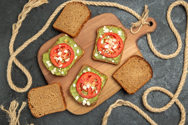 Top view delicious sandwiches with wassabi and red tomatoes on grey surface bread burger sandwich meal snack