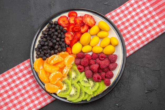 Top view delicious sliced fruits inside plate on dark photo mellow fruit tree exotic ripe healthy life