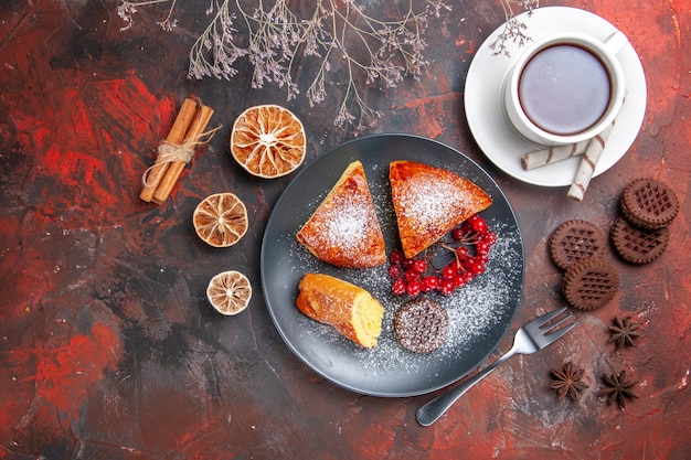 Top view delicious sliced pie with cup of tea on the dark table cake sweet pie tea