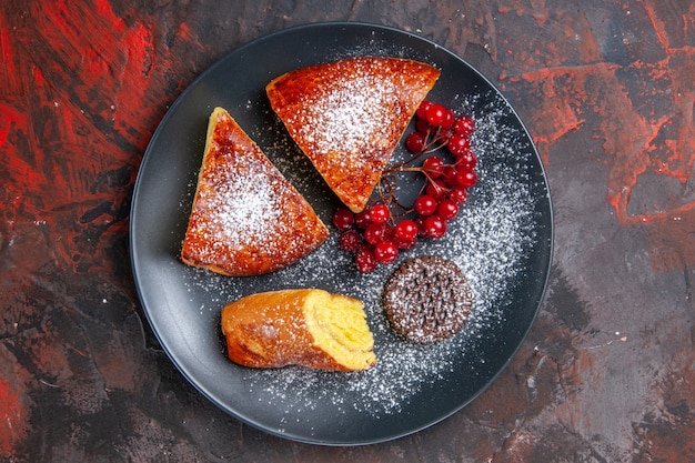 Top view delicious sliced pie with red berries on dark table sweet pie cake