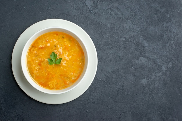 Top view delicious soup inside white plate on dark surface