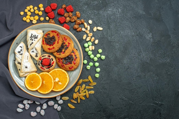 Free photo top view delicious sugar cookies with pastries and orange slices on dark surface sugar biscuit sweet cookie tea cake