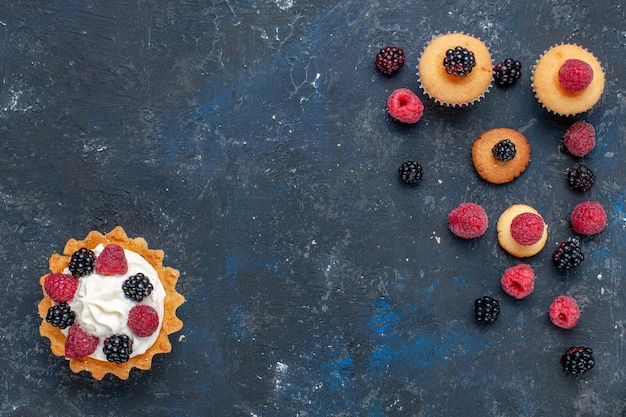 Free photo top view of delicious sweet cake with different berries and yummy cream on dark, fruit berry cake biscuit sweet