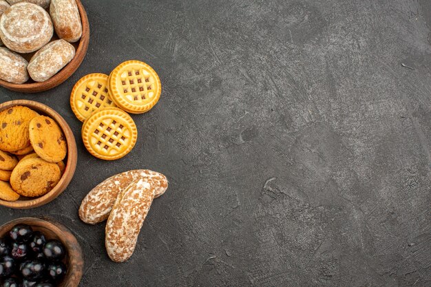 Top view delicious sweet cakes with cookies and olives on the dark surface pie cake sweet